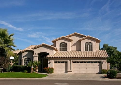 Two story home with three car garage in southwestern neighborhood of Scottsdale, AZ has tiled roof, palm trees, is new,