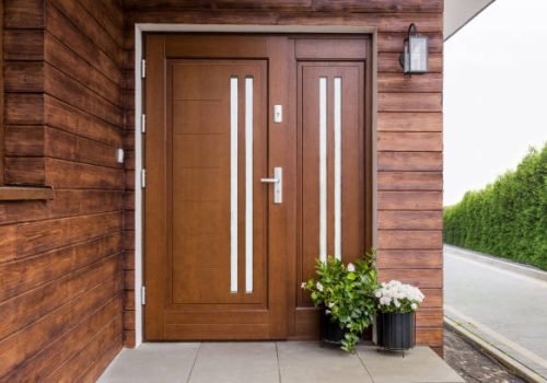 Designer entrance door to a country house. Modern design. luxurious exterior. Facade of a modern building with modern door.